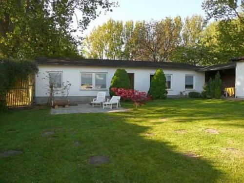 a white house with a patio and a yard at Ruegen_Fewo 102 in Sagard
