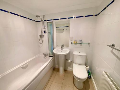 a bathroom with a toilet and a tub and a sink at Golf Court View, Elie in Elie