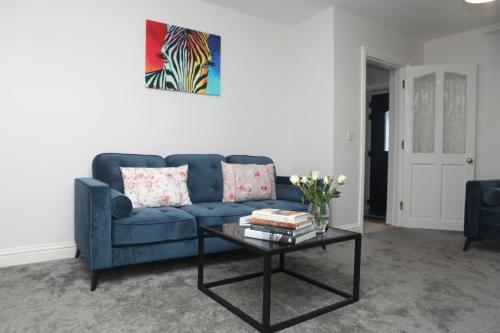 a living room with a blue couch and a coffee table at Killala 3 bed house in Killala