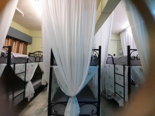 Un dormitorio con tres literas con cortinas blancas. en My Travel Homestay, en Haad Rin