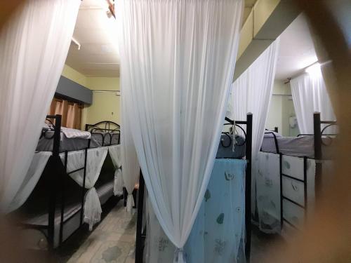 a room with three bunk beds with white curtains at My Travel Homestay in Haad Rin