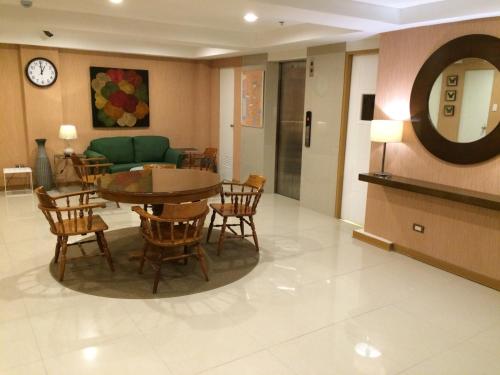a living room with a table and chairs and a couch at Stone House Hotel Pasay in Manila
