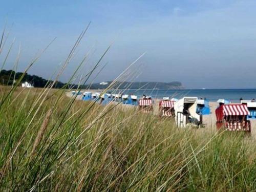 a beach with chairs and umbrellas and the ocean at Ruegen Fewo 207 in Moisselbritz