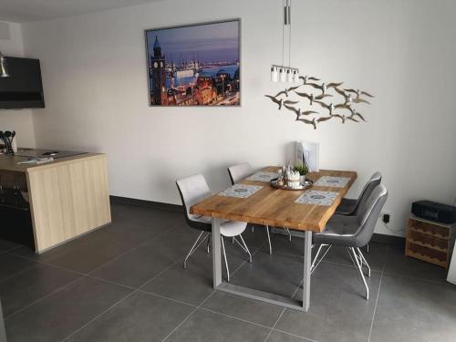 een eetkamer met een houten tafel en stoelen bij FeWo Pearl 207 am Yachthafen inkl. Tiefgarage in Bremerhaven