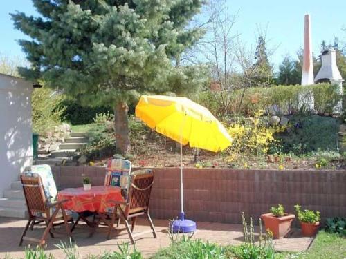 a table with a yellow umbrella in a garden at Ruegen Fewo 208 in Gremmin