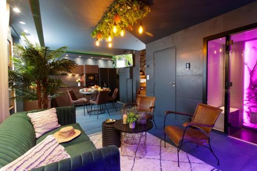 a living room with a green couch and purple lighting at Sweety Loft Suites romantique avec jacuzzi in Friville-Escarbotin
