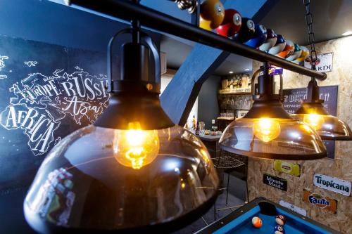 a group of lights hanging from a bar with a table at Sweety Loft Suites romantique avec jacuzzi in Friville-Escarbotin