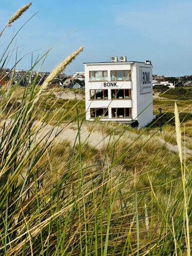 un edificio en la playa junto a un campo de césped en BONK suites, en Middelkerke