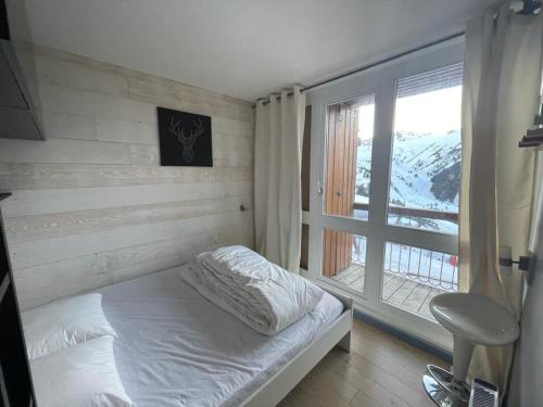 une chambre avec un lit et une grande fenêtre dans l'établissement Appartement rénové 6 pers · Centre station · Balcon · TV · Lave-vaisselle · Lave-linge - FR-1-346-548, à Arc 1800