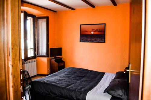 韋爾巴尼亞的住宿－Ciceri Properties Ciancino，一间卧室拥有橙色的墙壁和一张床及窗户