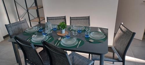 une table avec des assiettes, des verres et des chaises dans l'établissement Gîte de la Fecleval 6 personnes proche du Puy dufou, à Saint-Mesmin