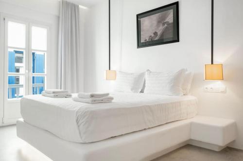 um quarto branco com uma grande cama branca com 2 toalhas em Luxury Apartment Center of Mykonos Town - Sleeps 4 em Míconos