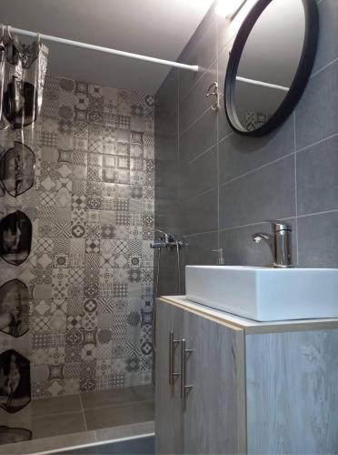 a bathroom with a sink and a mirror and a shower at Rafailia's House in Kallirákhi