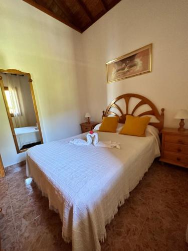 1 dormitorio con 1 cama blanca grande con almohadas amarillas en Casa Zaida, en San Sebastián de la Gomera