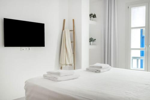 um quarto branco com uma cama com toalhas em Luxury Apartment Center of Mykonos Town - Sleeps 4 em Míconos