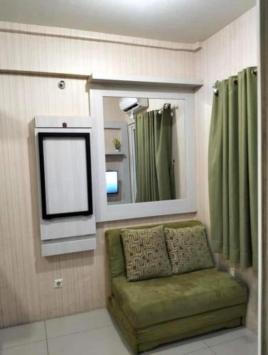 uma sala de estar com um espelho e um sofá verde em ilham ganteng hote em Serang