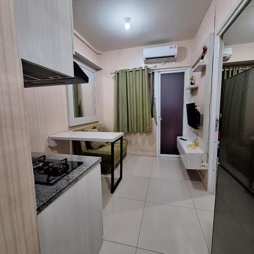 uma pequena cozinha com um lavatório e um fogão em ilham ganteng hote em Serang