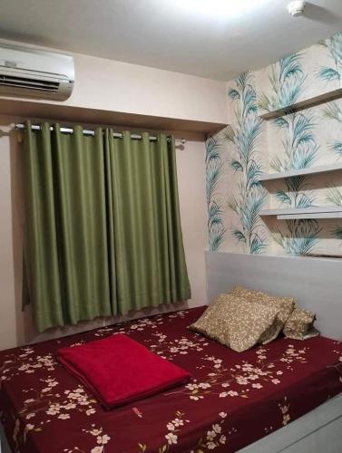 um quarto com uma cama com uma cortina verde em ilham ganteng hote em Serang