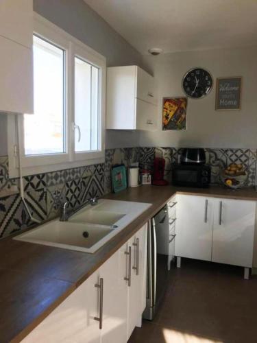 une cuisine avec un évier et un plan de travail dans l'établissement Maison avec piscine privée aux portes des Cévennes, à Saint-Christol-lès-Alès