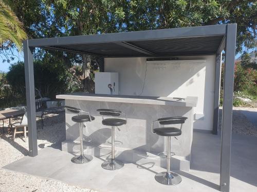 a barbecue grill with stools under a canopy at elparaiso-altea Luxury Apartment "CIELO" ADULTS ONLY Bed & Borrel in Altea