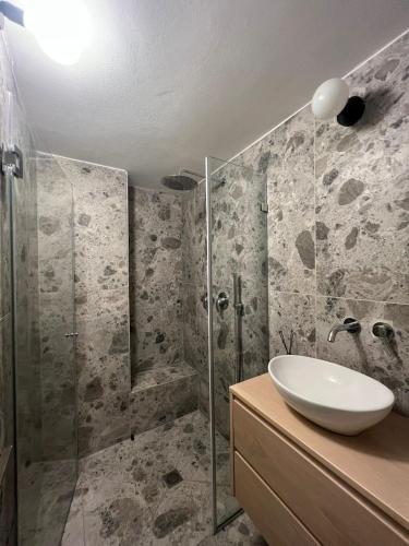 a bathroom with a sink and a shower at דירת גן על הים בנהריה in Nahariyya