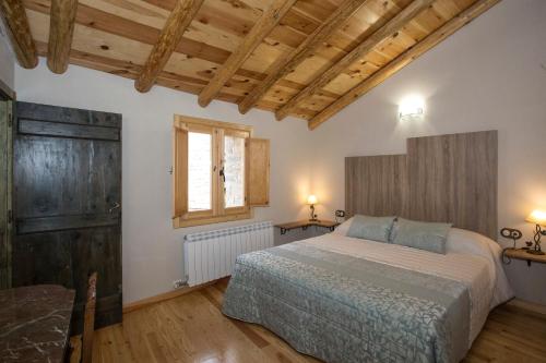 um quarto com uma cama, uma janela e tectos em madeira em Casa rural La Masadría em Mondot