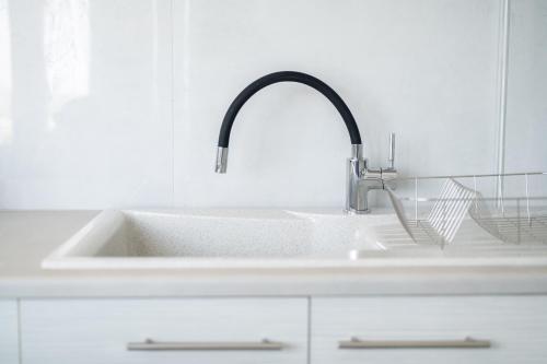 a sink with a faucet in a white kitchen at Saint Nicholas Houses in Kefalos