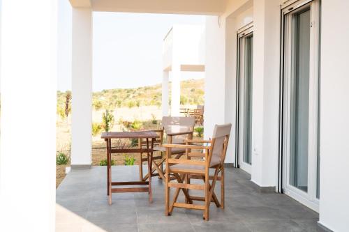 Un patio con sillas y una mesa en el balcón. en Saint Nicholas Houses en Kéfalos