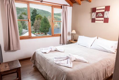 a bedroom with a bed with towels on it at El Viejo Nogal in San Martín de los Andes