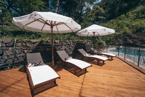 a group of chairs and umbrellas on a deck at Suitree Experience Hotel in Guanacaste