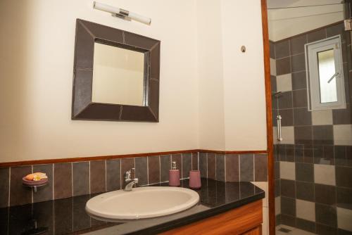 La salle de bains est pourvue d'un lavabo et d'un miroir. dans l'établissement Lovely 2 Bedroom Duplex next to the Beach, à Cap Malheureux