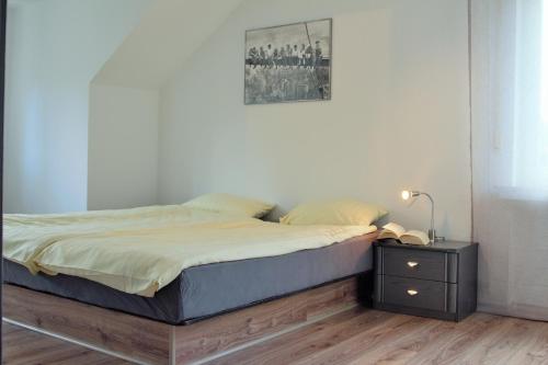 1 dormitorio con 1 cama y mesita de noche con una foto en Ferienhaus Winterberg en Winterberg