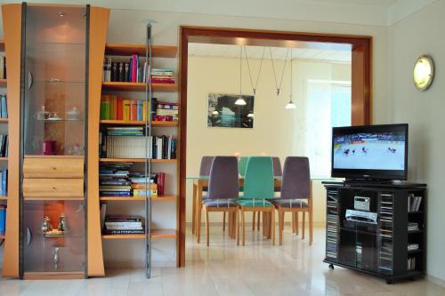 a living room with a television and a table with chairs at Ferienhaus Winterberg in Winterberg