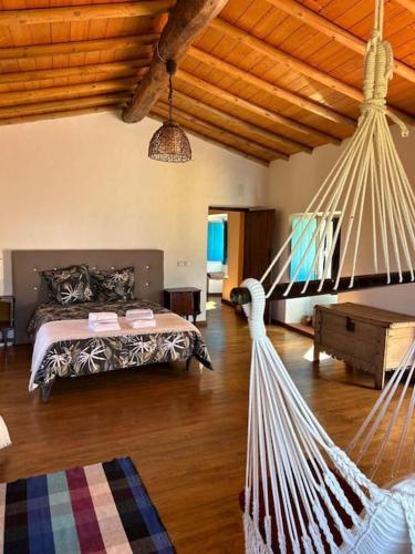 a bedroom with a bed and a hammock in it at Art-Marvão, Alojamento Rural in Marvão