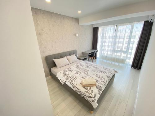 sypialnia z łóżkiem, biurkiem i oknem w obiekcie Ultracentral Modern Apartment w Kiszyniowie
