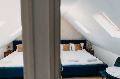 a bedroom with two beds in a attic at Palma Vendégház in Szeged