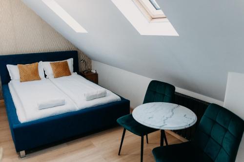 a bedroom with a bed and a table and chairs at Palma Vendégház in Szeged