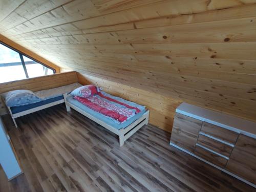 Habitación con 2 camas en una cabaña de madera en Domek nad rzeką Rospuda 