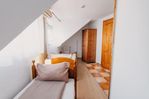 a small room with two beds and a window at Palma Vendégház in Szeged