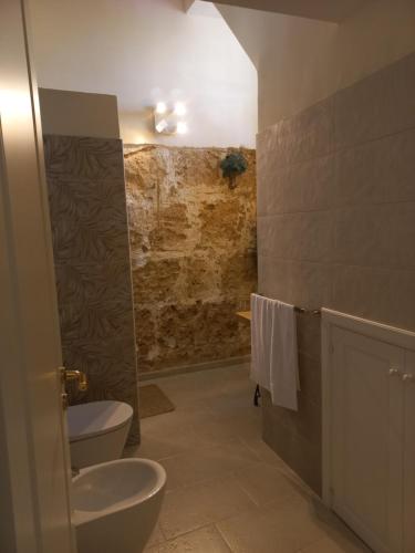 La salle de bains est pourvue de toilettes, d'une douche et d'un lavabo. dans l'établissement Casa Pupi, à Noto