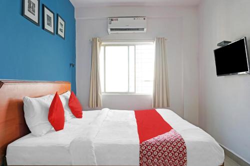 una camera con un letto con una coperta rossa e bianca di OYO Flagship 84826 Hotel Silver Key a Méribel Village