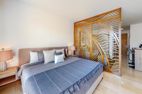 a bedroom with a bed with a large wooden headboard at Perfect Place 311 in Playa del Carmen