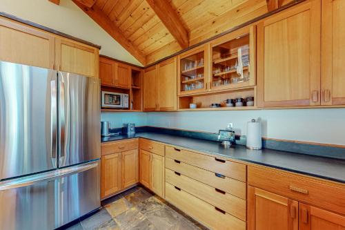 a kitchen with wooden cabinets and a stainless steel refrigerator at Epic Mountain Escape in Tahoe Vista