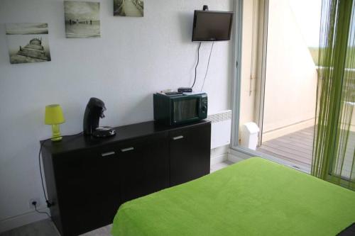 Cette chambre comprend un lit et une télévision sur une commode. dans l'établissement Studio 23, Héliopolis L, village naturiste,, au Cap d'Agde