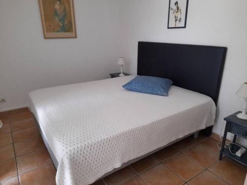 - un lit avec un oreiller bleu dans l'établissement Villa 34, Port Nature Village, Quartier naturiste, au Cap d'Agde