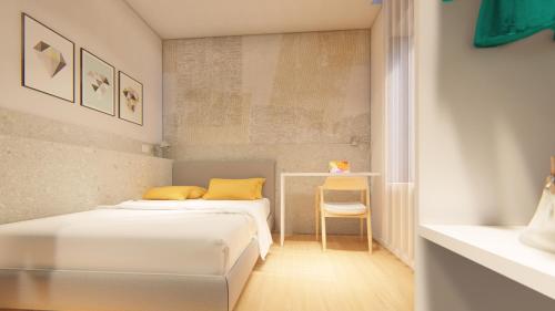 two beds in a small room with a table at Harbor Rooms - Cala Gonone in Cala Gonone