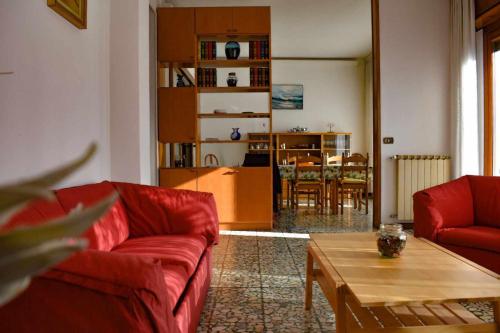 Ciceri Properties Montebello في فيربانيا: غرفة معيشة بها كنبتين حمراء وطاولة