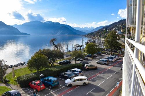 a city with cars parked on a street next to a body of water at Ciceri Properties Montebello in Verbania