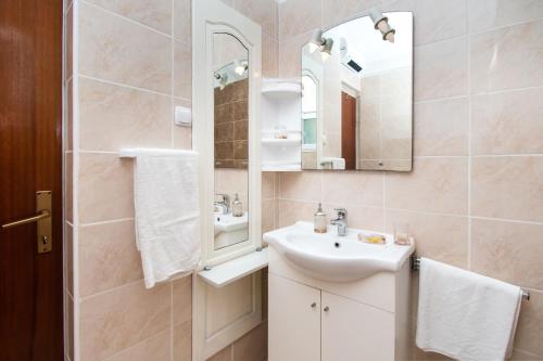 La salle de bains est pourvue d'un lavabo et d'un miroir. dans l'établissement Apartment Ivan Vrsi, à Vrsi