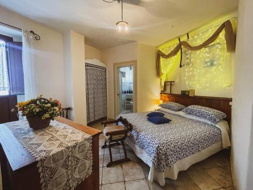 マッサフラにあるNovecento Room and Breakfast Pugliaのベッドルーム1室(ベッド1台、テーブル、窓付)